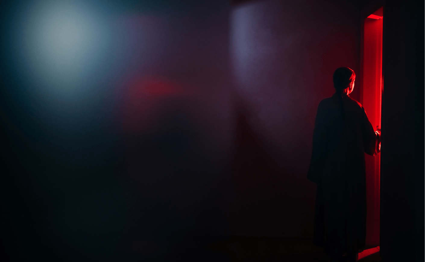 Silhouetted woman standing near a red-lit doorway in Katie Couric Media’s postpartum psychosis article artwork